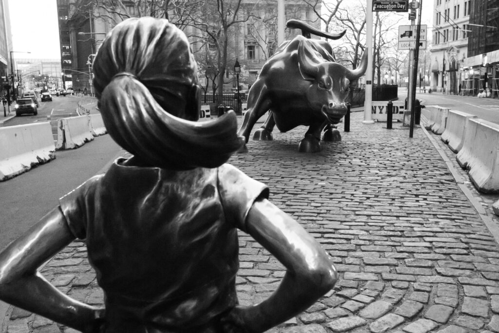 escultura de garota em frente a touro na frente do prédio de Wall Street