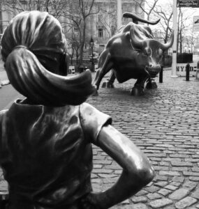 escultura de garota em frente a touro na frente do prédio de Wall Street