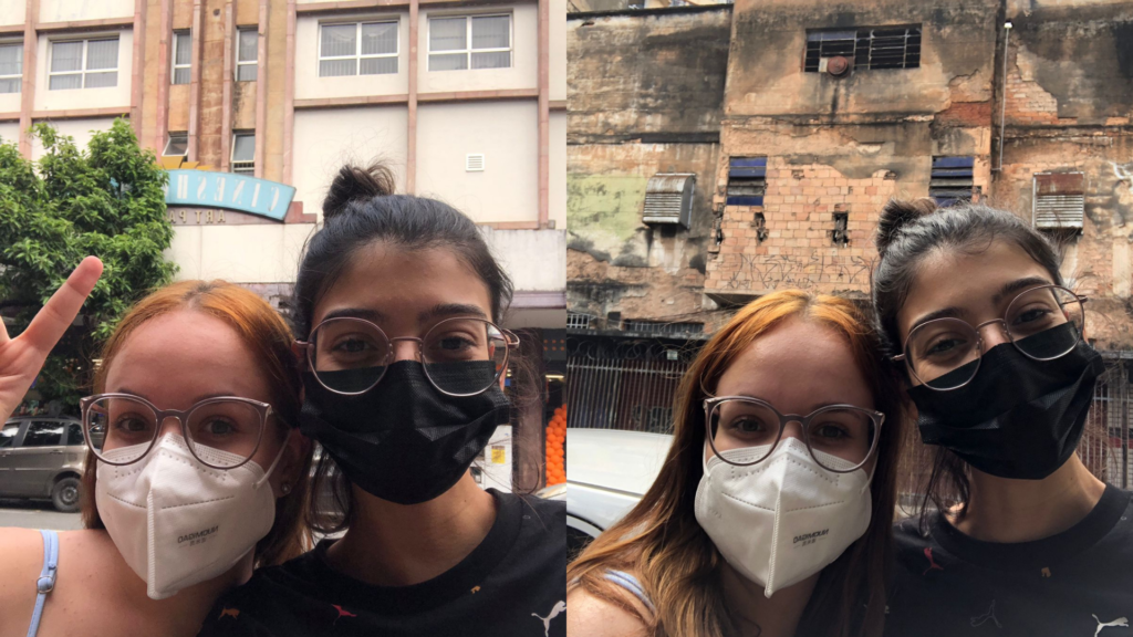 Colagem de duas fotos das estudantes Sofia (de cabelo ruivo, à esquerda) e Sarah (de cabelo castanho, à direita) durante visitação do Cine Art Palacio - prédio antigo em tons pasteis de laranja e azul.