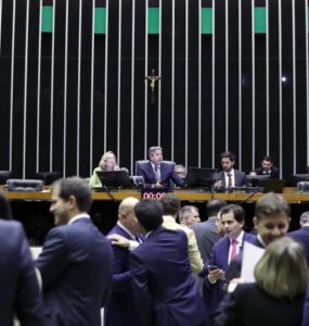 Imagem com enfoque na mesa diretora da Câmara dos Deputados. Da esquerda para direita: Maria do Rosária (PT-RS), mulher branca e loira, e Arthur Lira (PP-AL), homem branco, grisalho e de terno.