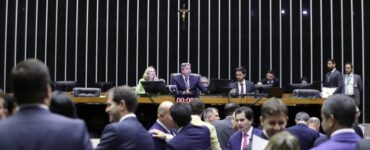 Imagem com enfoque na mesa diretora da Câmara dos Deputados. Da esquerda para direita: Maria do Rosária (PT-RS), mulher branca e loira, e Arthur Lira (PP-AL), homem branco, grisalho e de terno.