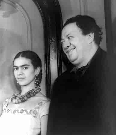 Fotografia em preto em branco com um casal. Na esquerda, Frida Kahlo e ao seu lado Diego Rivera