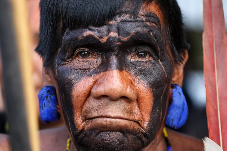 Indígena Yanomami de cabelos pretos e olhos preto, usa ornamento característico da sua cultura na sua orelha e em seu pescoço.