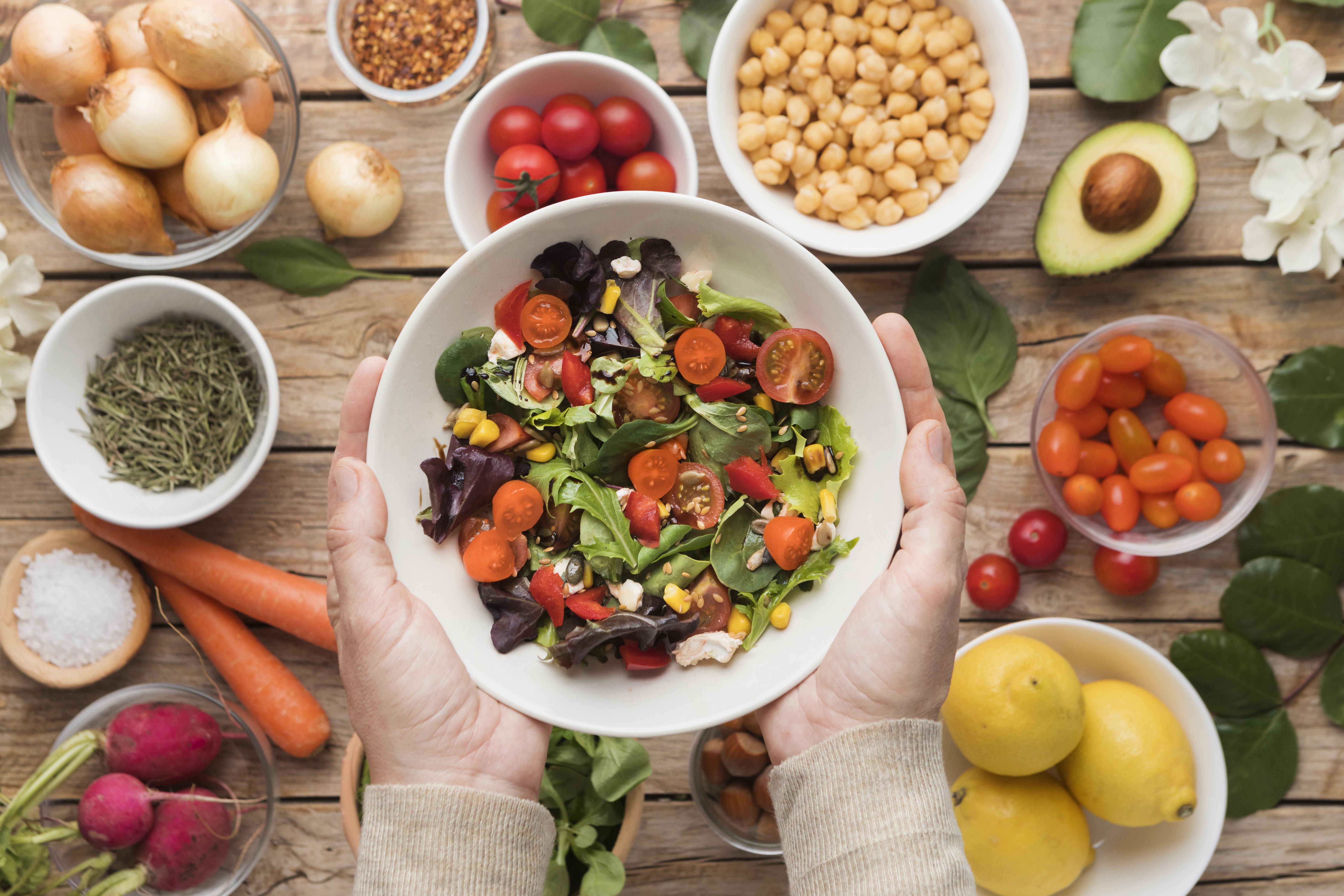 Muitos vegetais e legumes distirbuidos em tigelas em uma mesa