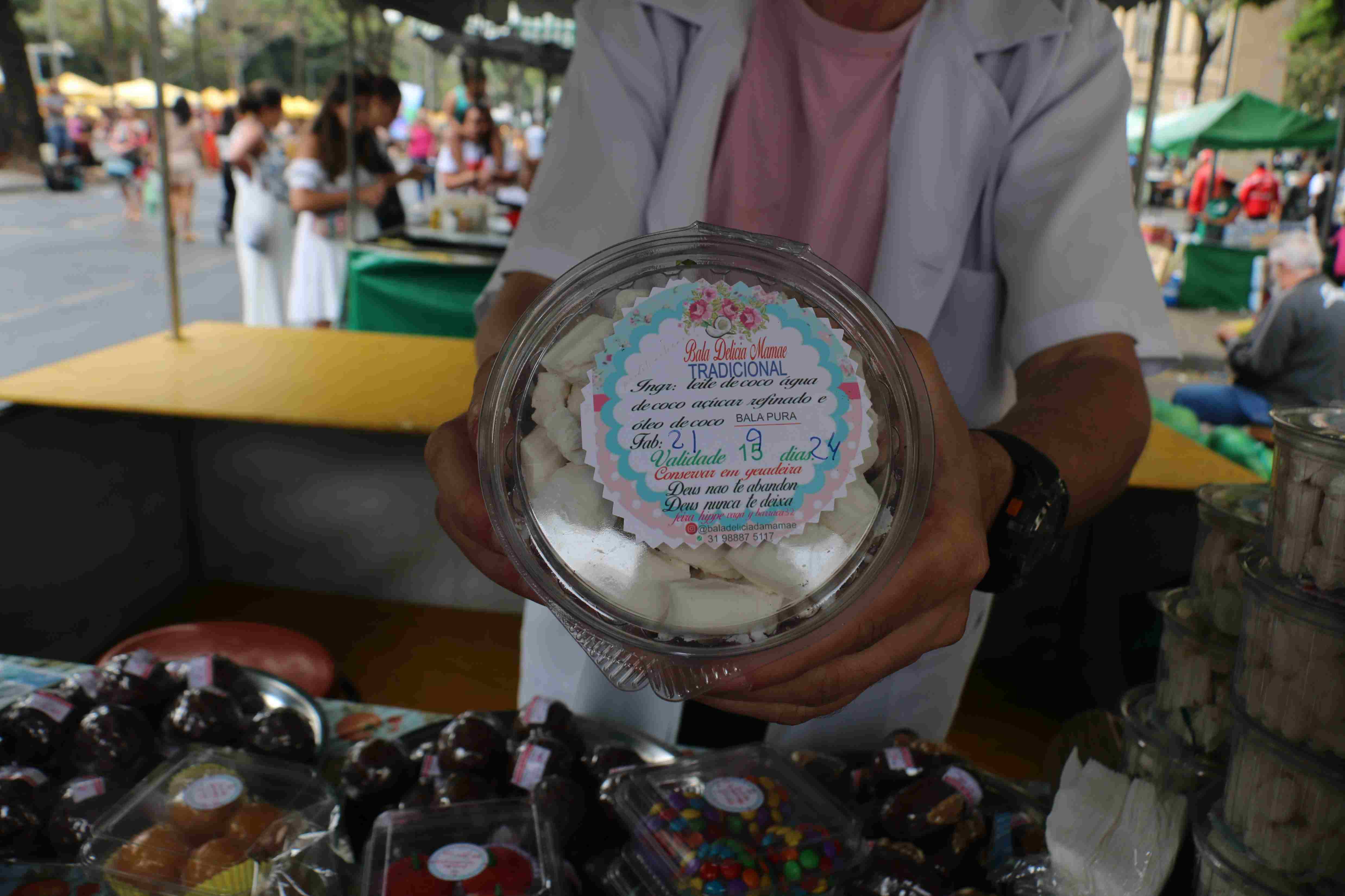 vendedor segurando doces de coco