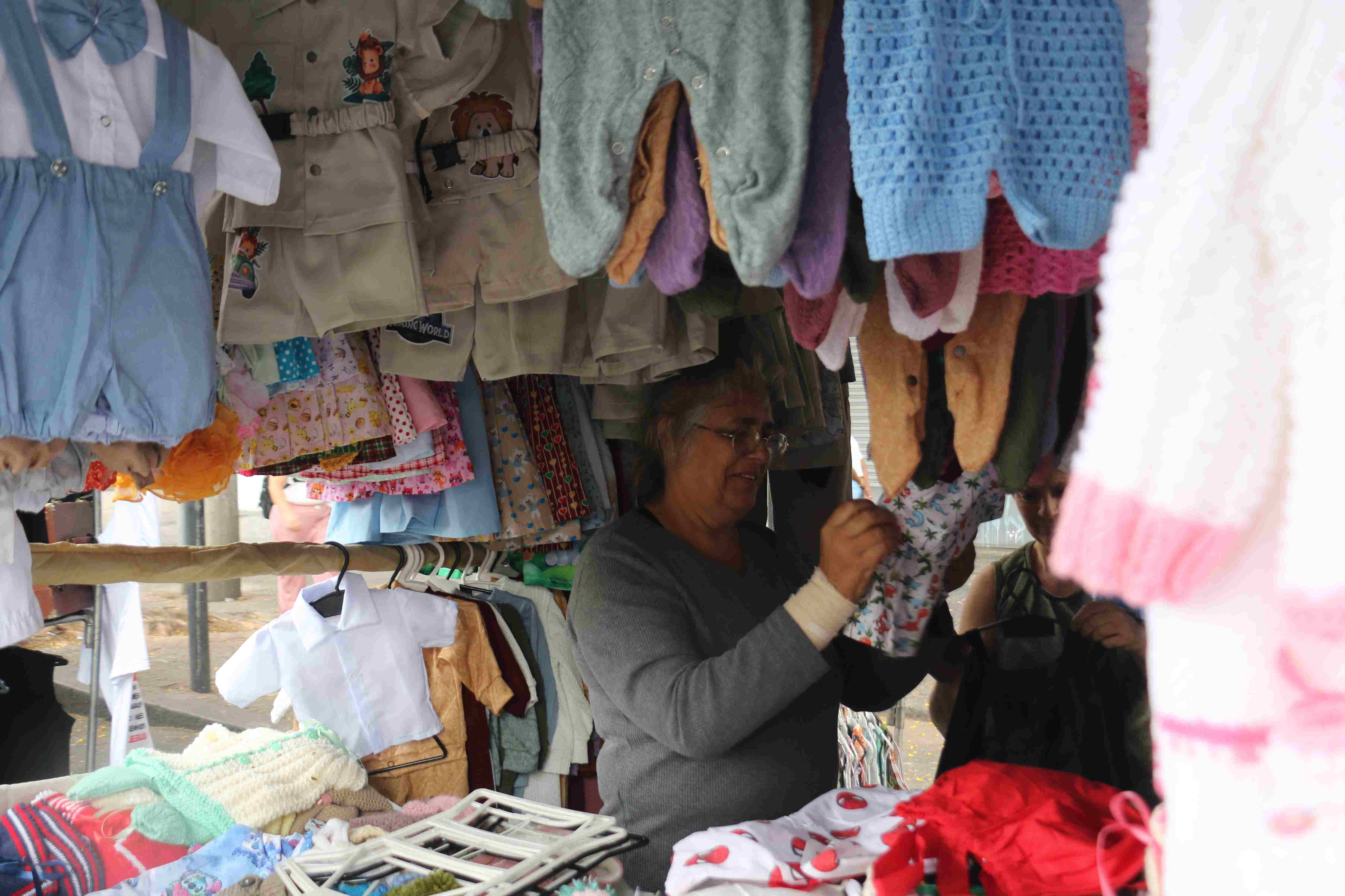 foto de uma barraca de roupas de croché para recém nascidos 