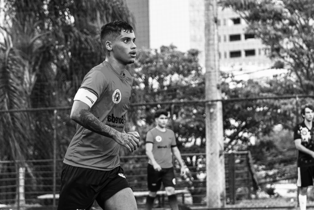 Foto em preto e branco de um atleta correndo em campo