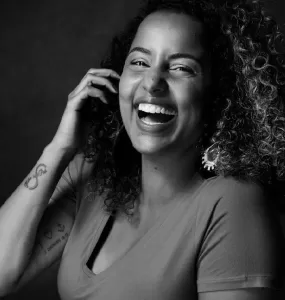 retrato em preto e branco de Tábata sorrindo em primeiro plano