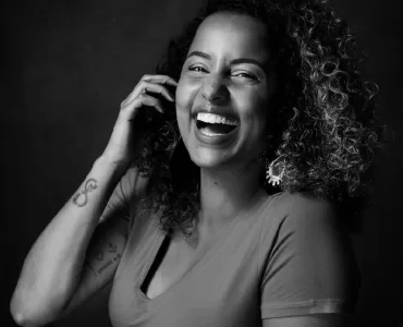 retrato em preto e branco de Tábata sorrindo em primeiro plano