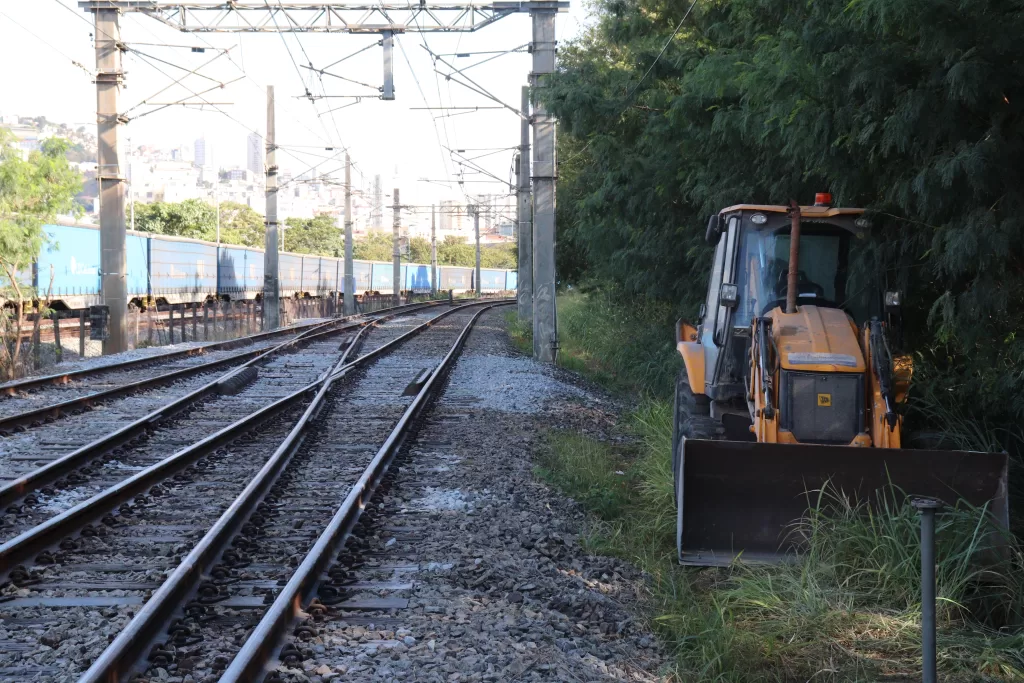 Trilho instalado em canteiro de obras da Linha 2 do Metrô de Belo Horizonte, com trator ao lado