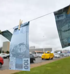 Varal de corda com notas falsas de 100 reais espalhadas na Esplanada dos Ministérios, na altura do Museu Nacional da República em Brasília, DF, em protesto de 2015. A iniciativa é do Sindicato Nacional dos Procuradores da Fazenda Nacional.