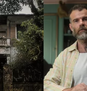 A imagem é dividida em duas partes. A parte da esquerda mostra uma casa antiga coberta por vegetação de ambos os lados, com sua fachada grafitada e uma estrutura desgastada. Na parte da direita, observa-se Chico Felitti em primeiro plano, ele é branco, tem cabelo curto loiro escuro, usa uma regata simples de cor branca e uma camisa xadrez por cima dela. O cenário aparenta ser uma casa, com uma estante à direita de Chico, e uma parede verde escura ao fundo.