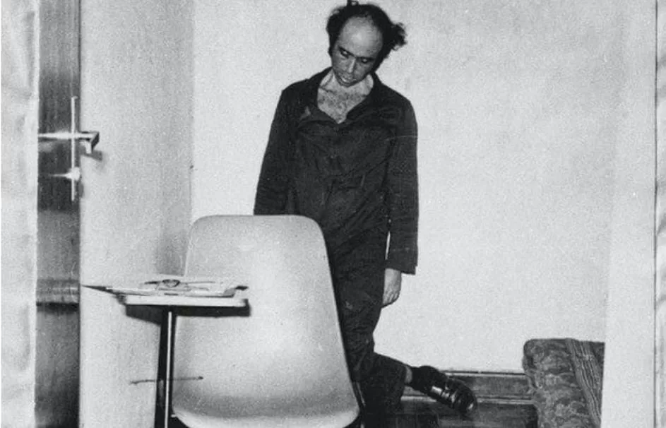 imagem em preto e branco do suicidio forjado de Vladimir Herzog, ele está pendurado com uma coda amarrada no pescoço