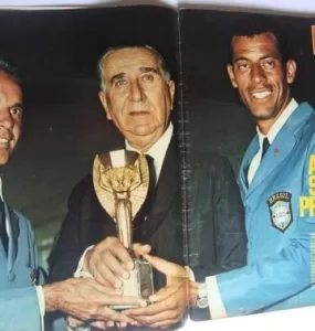 página de revista com foto de atletas da seleção brasileira e de Médici segurando a taça Jules Rimet com a manchete escrita “A taça sem protocolo”