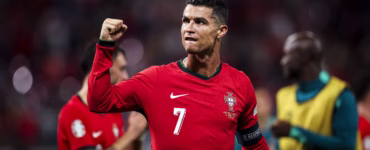 Cristiano Ronaldo comemora durante partida da Seleção Portuguesa, usando a camisa vermelha número 7 e levantando o punho em campo