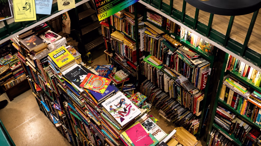 Interior do Sebo Poesis com estantes repletas de livros e revistas organizados em prateleiras.