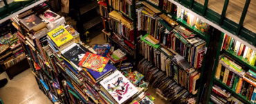 Interior do Sebo Poesis com estantes repletas de livros e revistas organizados em prateleiras.