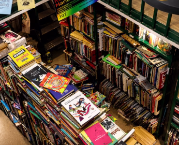 Interior do Sebo Poesis com estantes repletas de livros e revistas organizados em prateleiras.